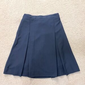 Navy blue pleated skirt with adjustable waist.
